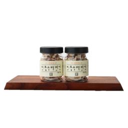 two jars of sea salt on a wooden board