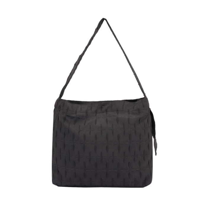 black quilted bag with a long strap and tassels