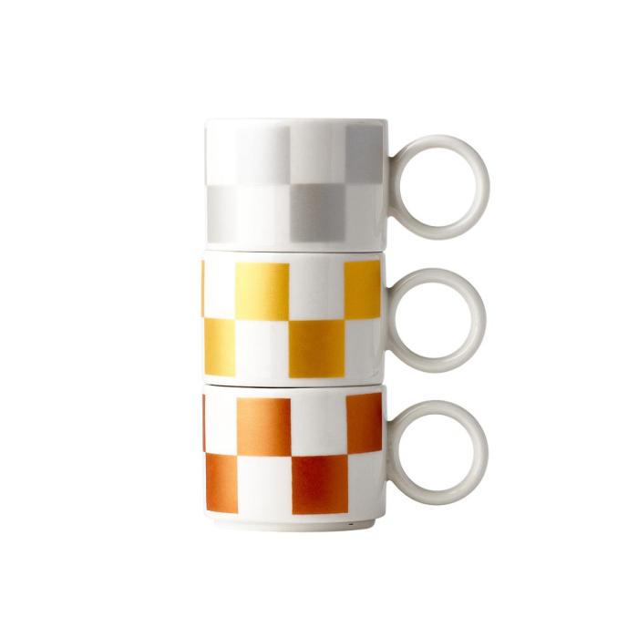 ceramic mugs and coasters with a checkerboard pattern in white and orange