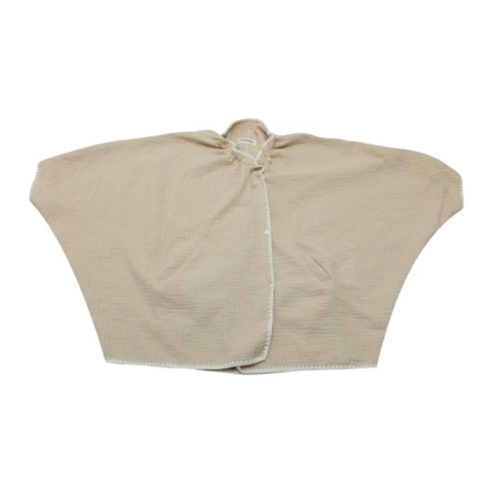 a beige linen shirt with a tie at the waist