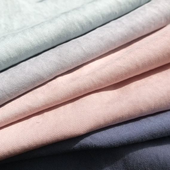 TENCEL HIGH-DENSITY TWILL is a luxurious, durable fabric made from a 54% TENCEL and 46% COTTON blend, offering exceptional comfort, strength, and a subtle sheen, ideal for outerwear and home textiles.