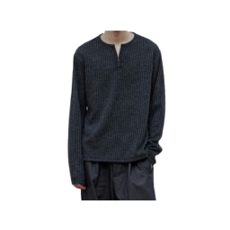 a dark blue knitted sweater with a white collar and black pants