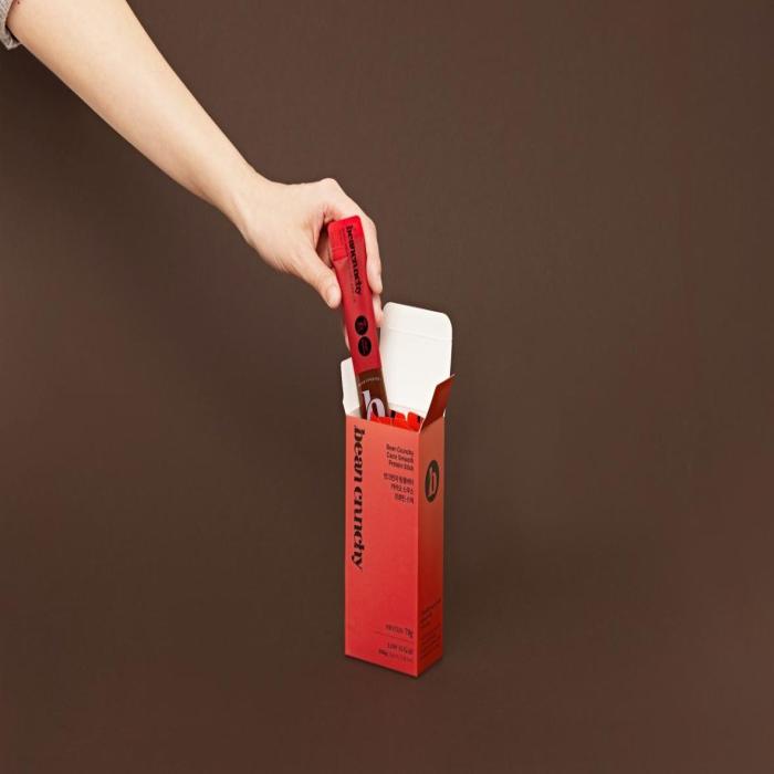 a hand opening a red box with a razor inside