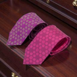 pink silk tie with a floral design and a purple silk tie with a floral pattern