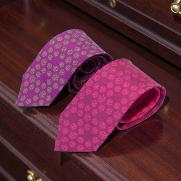 pink silk tie with a floral design and a purple silk tie with a floral pattern