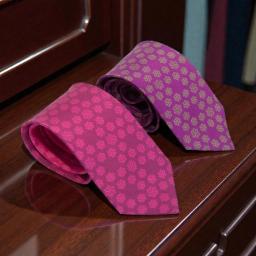 pink silk tie with a floral design and a purple silk tie with a floral pattern