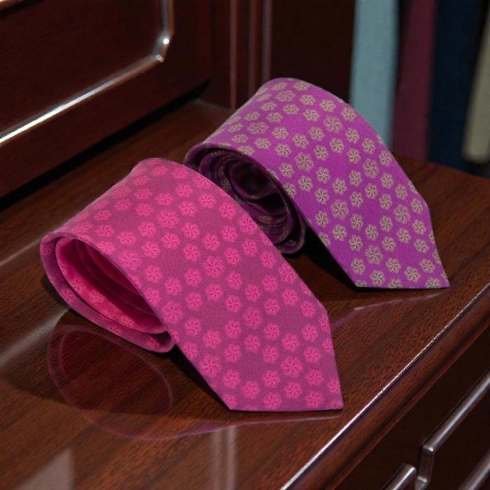 pink silk tie with a floral design and a purple silk tie with a floral pattern