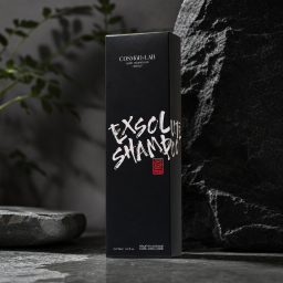 A tall, matte-black premium hair care box from COSMÖD:LAB, presented with a sleek, monolithic silhouette and understated luxury branding. The front features bold white brush-style lettering reading